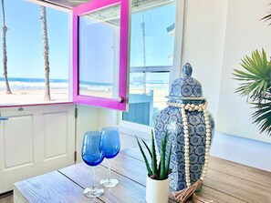 Charming, fully private beachfront cottage with signature pink door – steps from the sand in Oceanside, California."