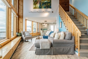 An open-concept living space designed for connection—complete with floor-to-ceiling windows and endless lake views.