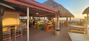 Several outdoor tiki huts and hot restaurant 