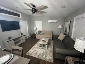 The beige couch is a sleeper sofa-folds out easily into a full memory foam bed.