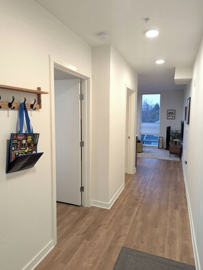 Entrance hallway. Bedroom door, bathroom door, and living area pictured.