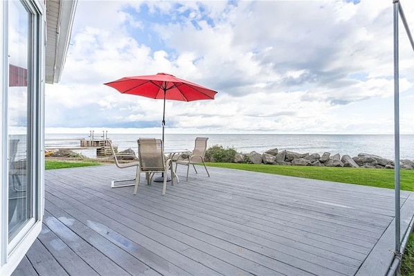 Dine al fresco with the sound of waves in the background. This spacious deck with seating and an umbrella is ideal for relaxing by the lake.
