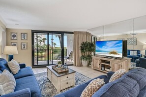 Open concept living area with TV balcony access and sleeper sofa