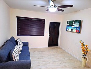 Front room with smart TV and couch with queen size bed