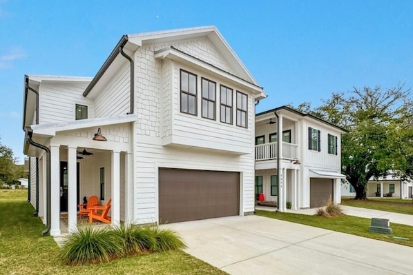 "The Orangery" with porch, garage & green lawn in a quiet Orange Beach suburb.