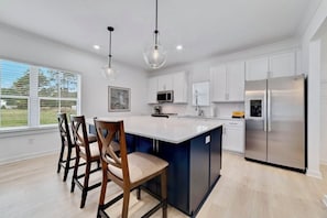 "The Orangery" boasts a sleek kitchen with a stylish island and cozy seating.