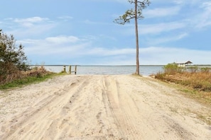 Scenic waterfront path leading to a serene lake with a peaceful dock.