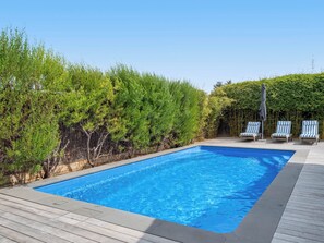 Enjoy the privacy of our sunlit pool, surrounded by lush greenery