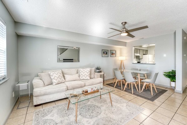 Spacious open-concept living and dining area with a sleek minimalist design, enhanced by a modern ceiling fan for comfort and style.
