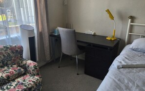 Desk and air cooler in bedroom.