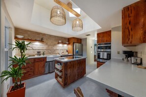 Completely remodeled kitchen with abundant natural light, farmhouse sink, and induction range in the island
