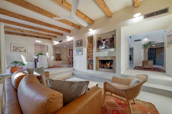 Living room with comfortable seating, smart TV, wood-burning fireplace, and beautiful, modern decor