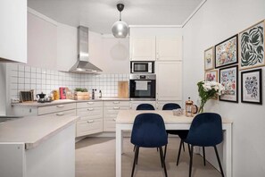 A functional and inviting kitchen space with a focus on natural light and art.