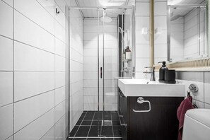 Dark wood vanity complements the white tile in this bathroom.