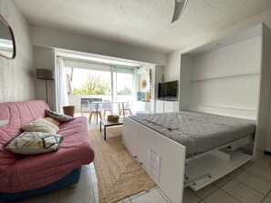 This living room offers a sleeping area with a double bed and a double sofa bed