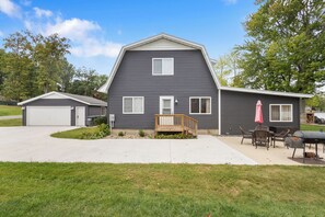 Side of the house with first outdoor seating area and grill 
