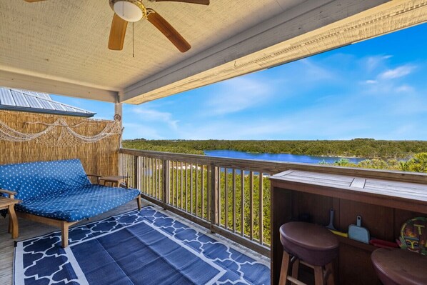 Private corner deck with double lounger and two person bar overlooking the water