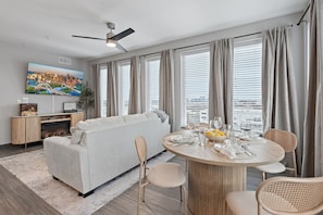 This warm and inviting space seamlessly blends the living and dining areas, creating the perfect setting for relaxation and connection. With cozy seating, a stylish dining table, and thoughtful décor, it offers a harmonious flow ideal for gathering, dining, and enjoying the city views.