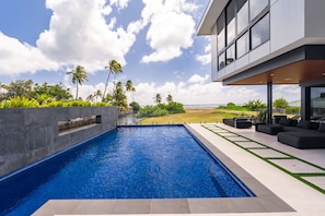 Lap pool lined with palms and sleek concrete—perfect for fitness and leisure in your private retreat.
