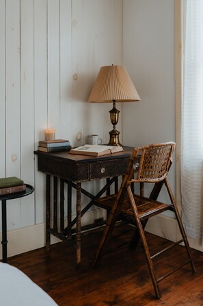 Thoughtfully designed with vintage-inspired furnishings, the Dickinson Room features a cozy corner with a reading table, warm lighting, and rustic wood details.