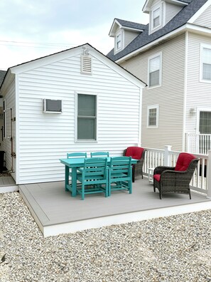 Back deck off of shared parking lot features seating for 6, propane grill.