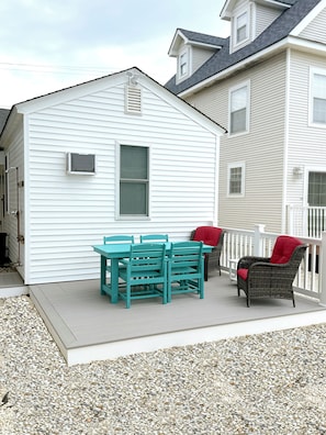 Back deck off of shared parking lot features seating for 6, propane grill.