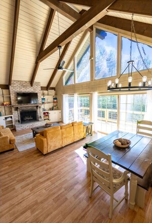 Open living and dining room area with large cathedral ceilings. 