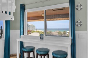 Dining area with bar height stools positioned to enjoy the beautiful and serene views!