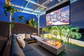 Rooftop lounge featuring a cozy fire pit surrounded by comfortable seating.