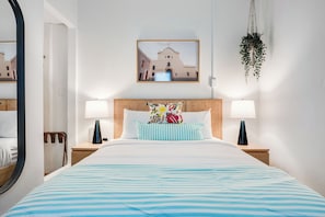 Cozy, modern bedroom, with wall painting and big mirror. Thoughtfully designed for ultimate comfort and relaxation.