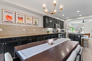 Elegant Dining Area – Spacious dining table with modern lighting, perfect for group meals.
