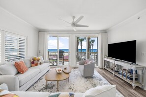 Living Room – A bright and spacious living area with cozy seating, a large flat-screen TV, and floor-to-ceiling windows offering stunning ocean views.
