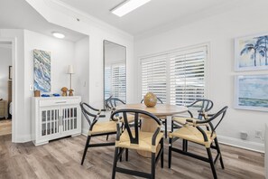Dining Area – A stylish dining space with seating for four, ideal for enjoying home-cooked meals with a beautiful beach backdrop.