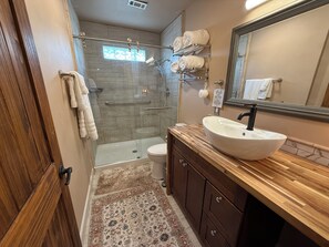 New Bathroom with large bowl sink, soaps, towels, washcloths and hairdryer.