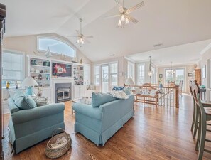 Open-concept living space with elegant hardwood floors and large windows offering scenic views.