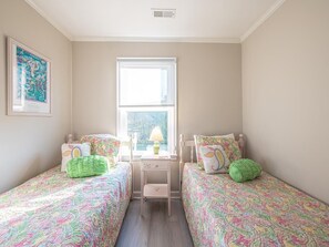 Bathed in natural light, this charming twin bedroom is a peaceful retreat with soft coastal tones.