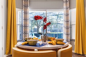 Sunny breakfast nook for 4 with pool view—perfect for coffee & connection.