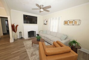Spacious living with functioning wood burning fireplace and75" TV