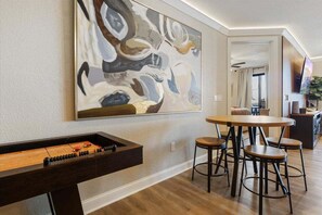 Fun on the shuffleboard table awaits in this chic living area.