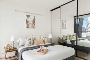 The master bedroom with a queen bed and plush pillows.