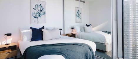 Bedroom 2 with large mirrored wardrobes and city skyline view