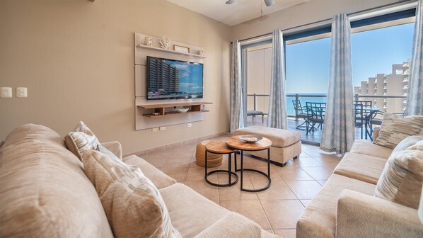 The warm and inviting living room with its TV, and twin sofas.