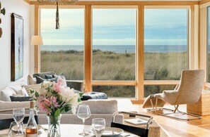 Ocean view dining room open to living room with gas fireplace, Dish and streaming TV, French doors to outside.