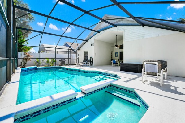 Relax and unwind in this screened-in private pool and spa area, perfect for soaking up the sun or enjoying a refreshing dip!