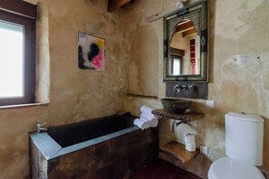 Baño independiente con amplias bañera y ducha de obra.