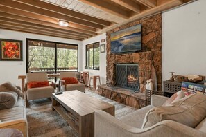 "Relax and gather in our inviting living space, where modern amenities meet rustic charm under exposed wooden beams.