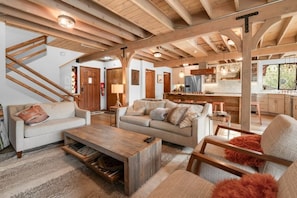 "Relax and gather in our inviting living space, where modern amenities meet rustic charm under exposed wooden beams.