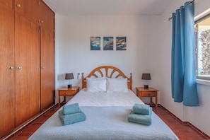 Quarto com camas de casal e ar condicionado