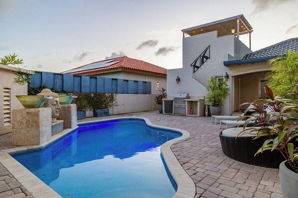 Escape to your own private pool oasis, complete with sun loungers, a cozy daybed, and tropical landscaping for the perfect Aruba getaway.