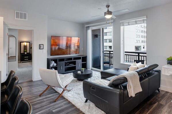 Beautifully designed living room. 75" TV, leather sofa and amazing views of mountains and city skyline.
